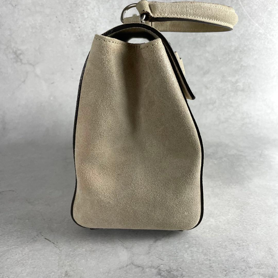 Side profile of the stone suede top-handle bag