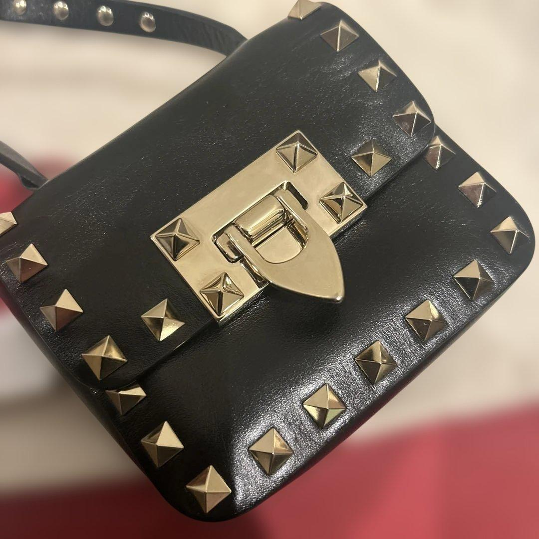 Close-up of the jewelled shield turnlock and pyramid studs