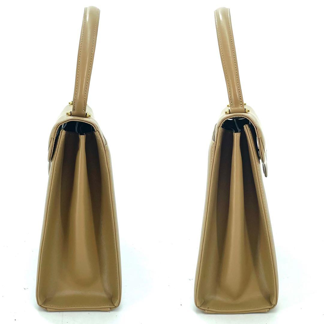 Side profile of the tan leather top-handle bag