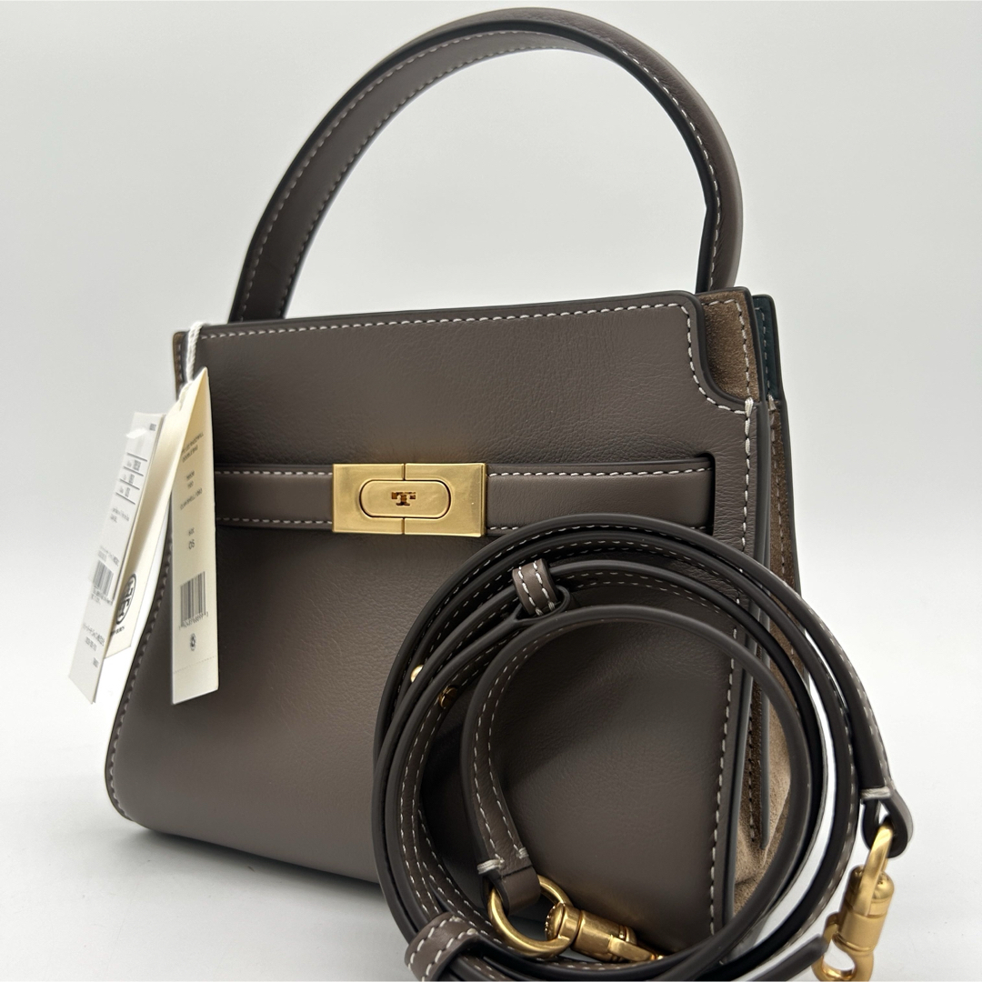 Angled view of the taupe top-handle bag with strap