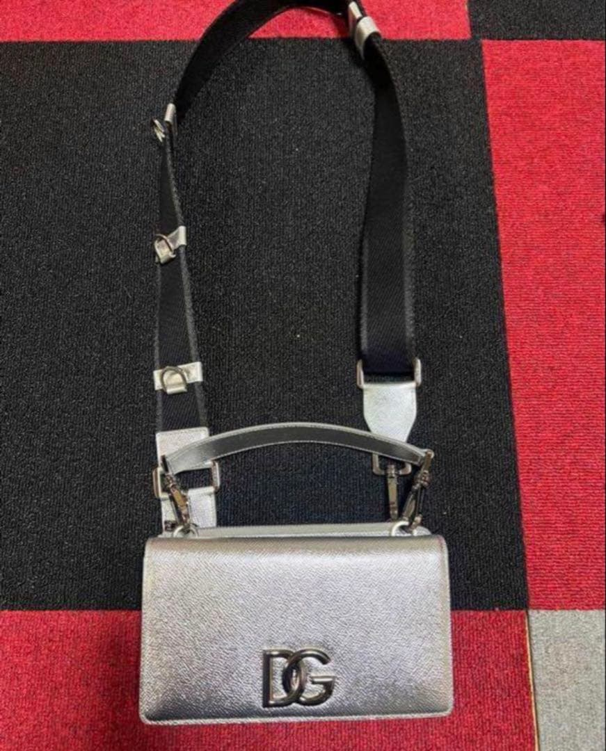 Angled view of the silver mini flap bag and webbing strap