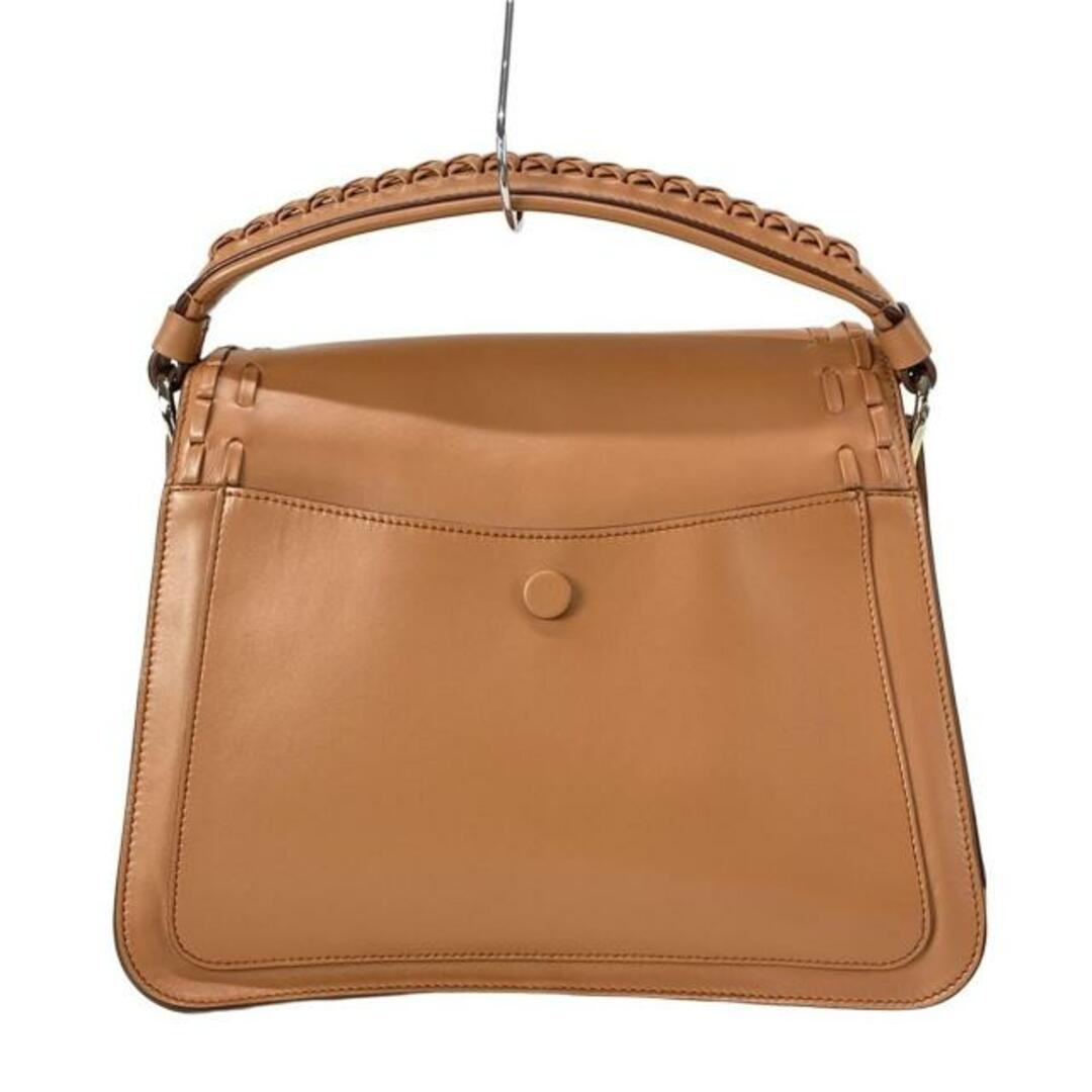 Back view of the tan flap bag with rear pocket and stud