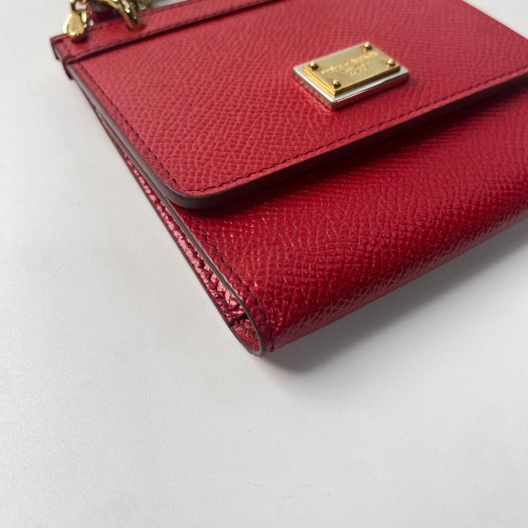 Close view of the red leather, stitching and gold plaque