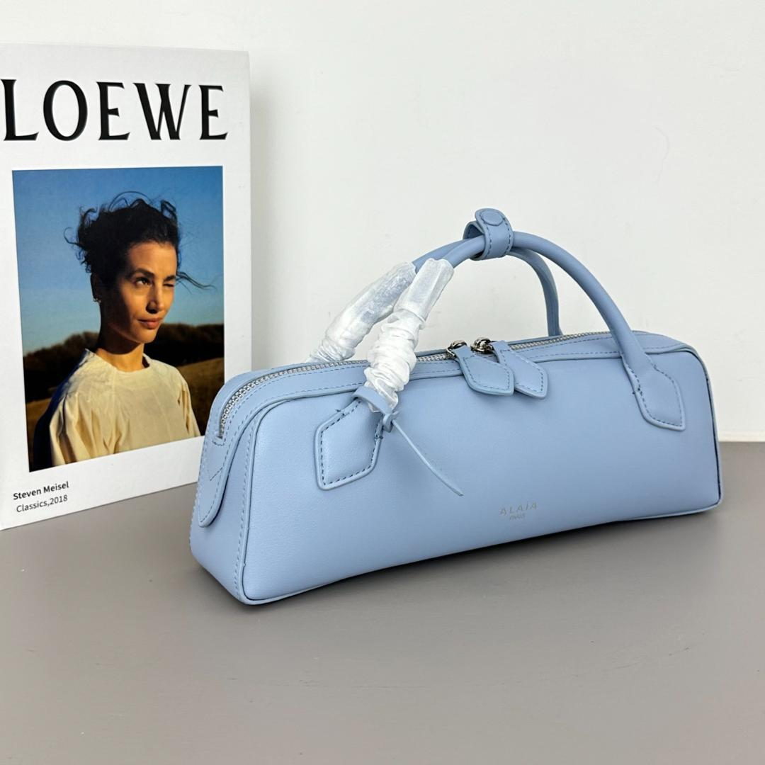 Angled view of the powder-blue east-west top-handle bag