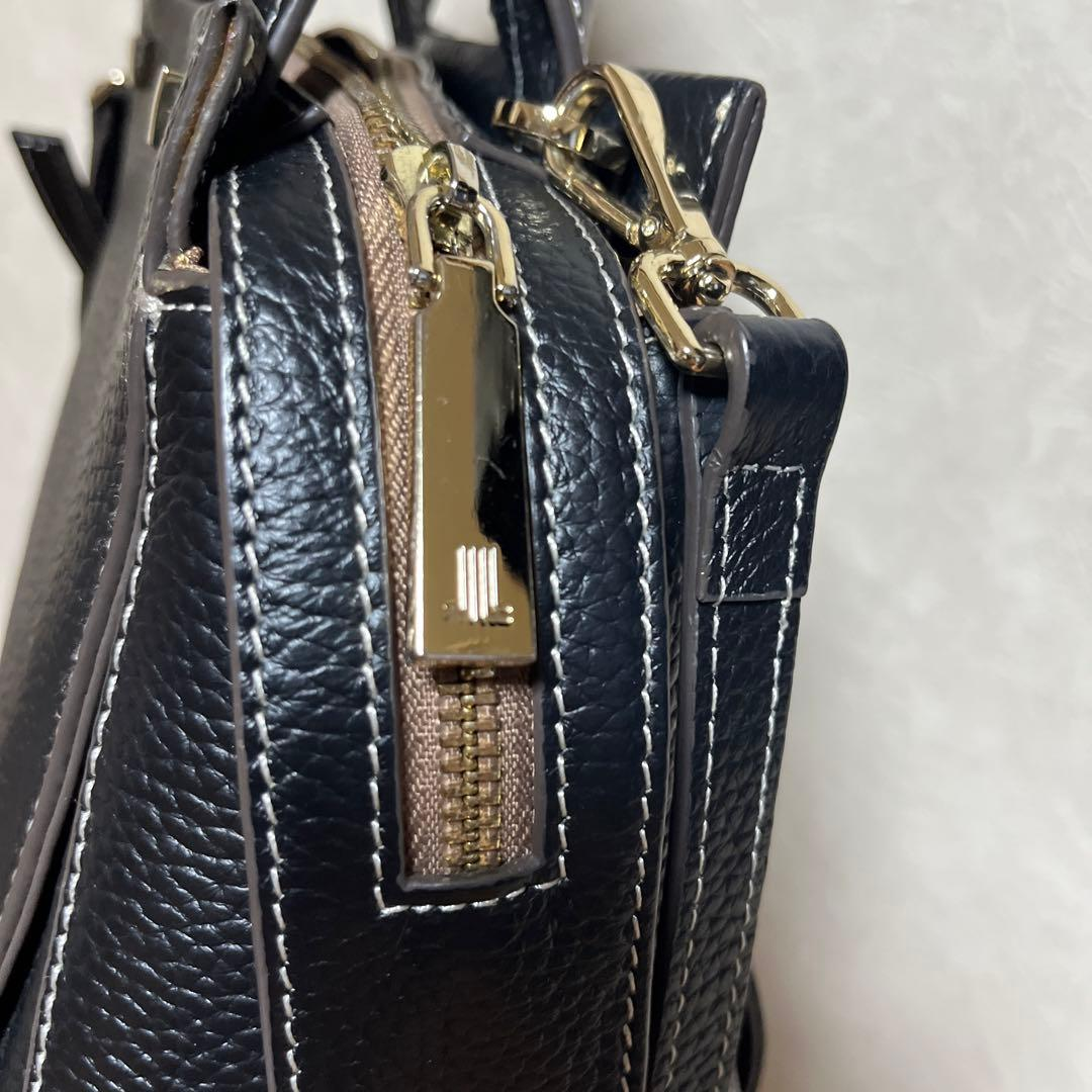 Close view of the gold JL zip pull and leather grain