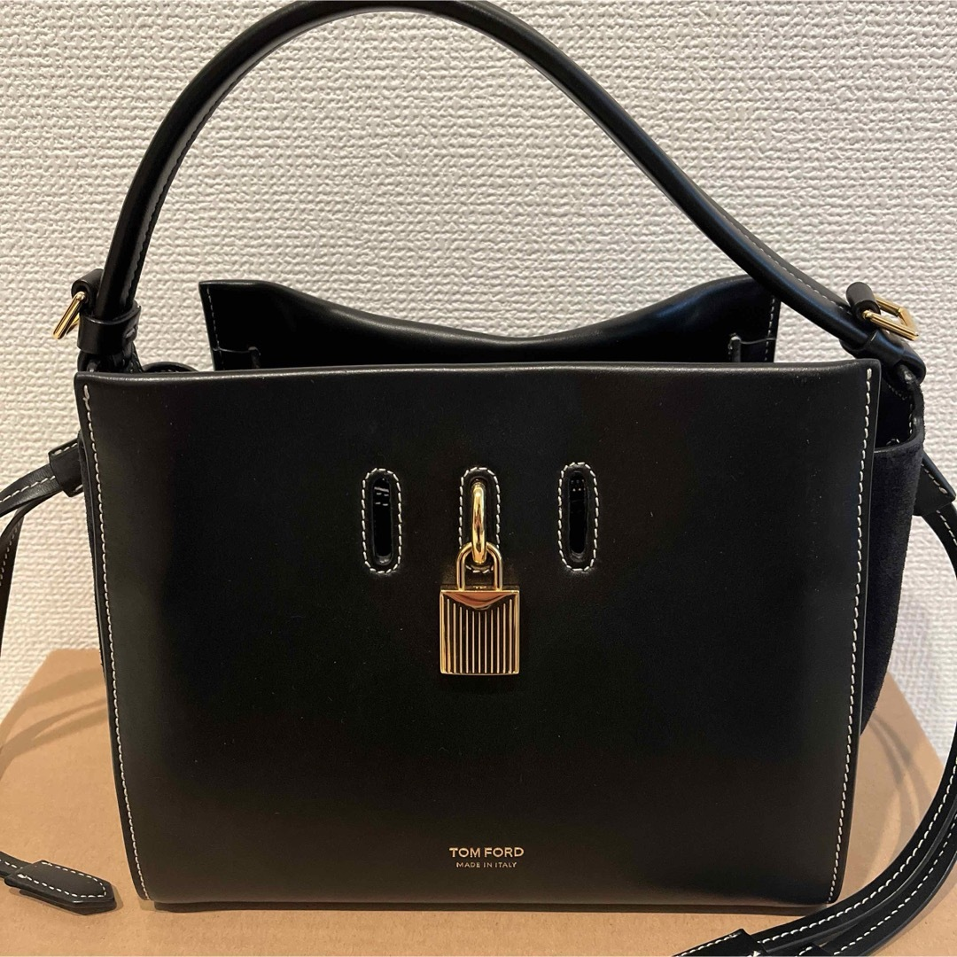Front view of the black leather padlock top-handle bag with gold hardware