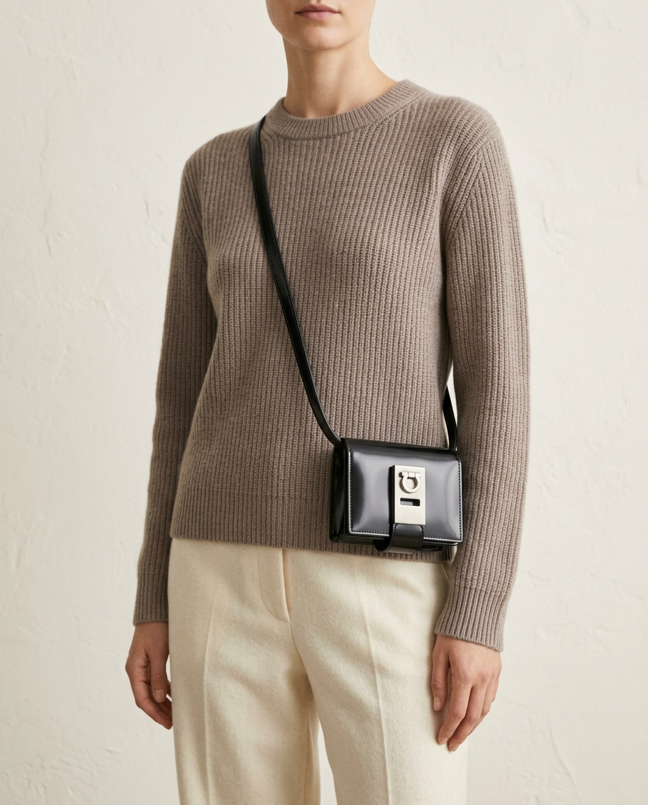 Model in a taupe knit wearing the black Gancini mini wallet-on-strap